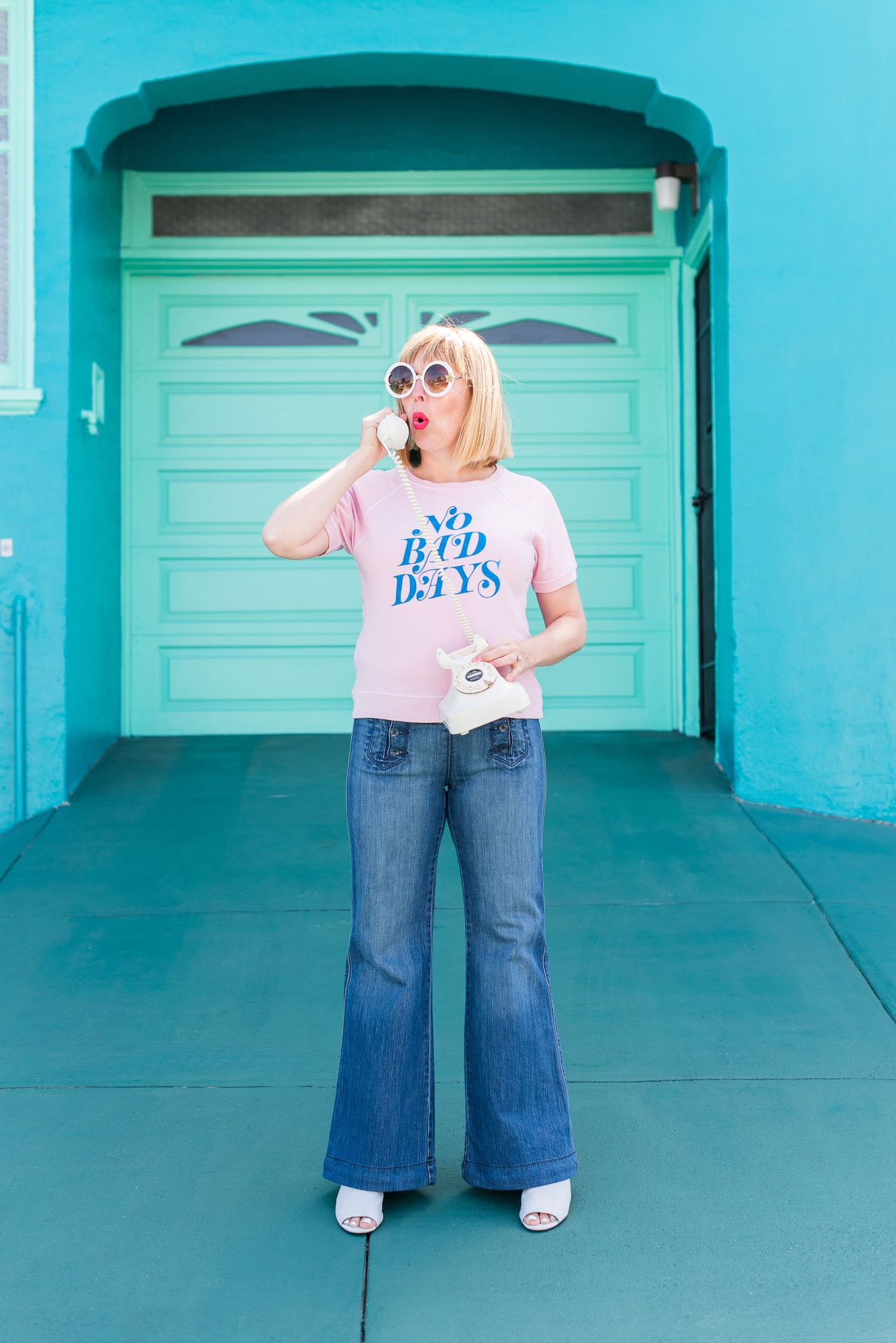 Kara on a cream rotary phone in a No Bad Days sweatshirt